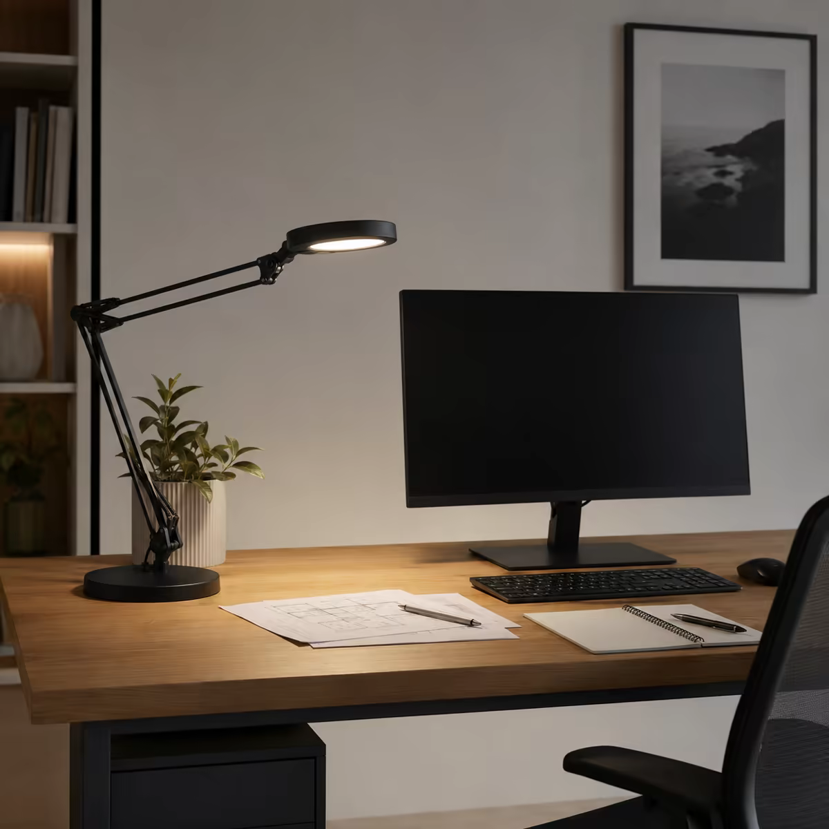 Nastavitelná stolní lampa osvětlující dokumenty vedle monitoru